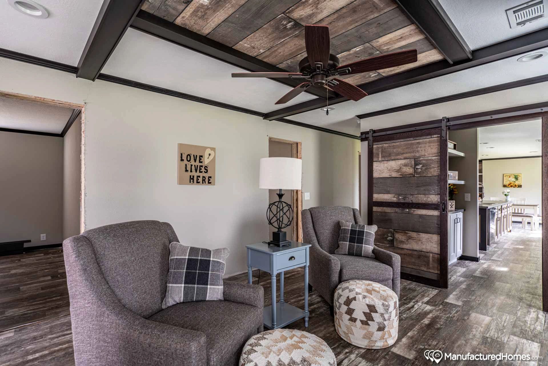 A living room with two chairs and a ceiling fan.