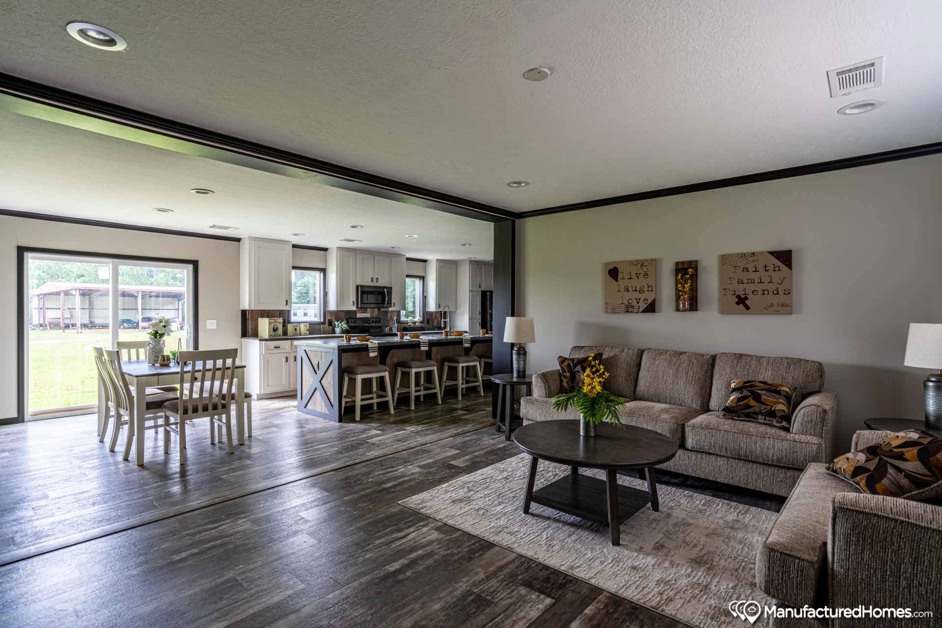 A living room with a couch , table , chairs and a dining room.