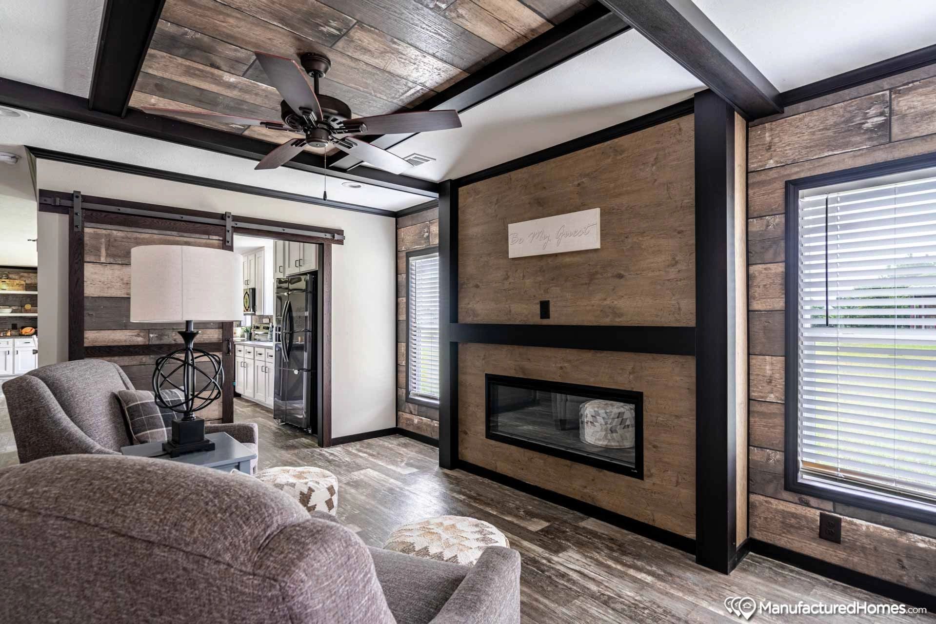 A living room with a fireplace and a ceiling fan.