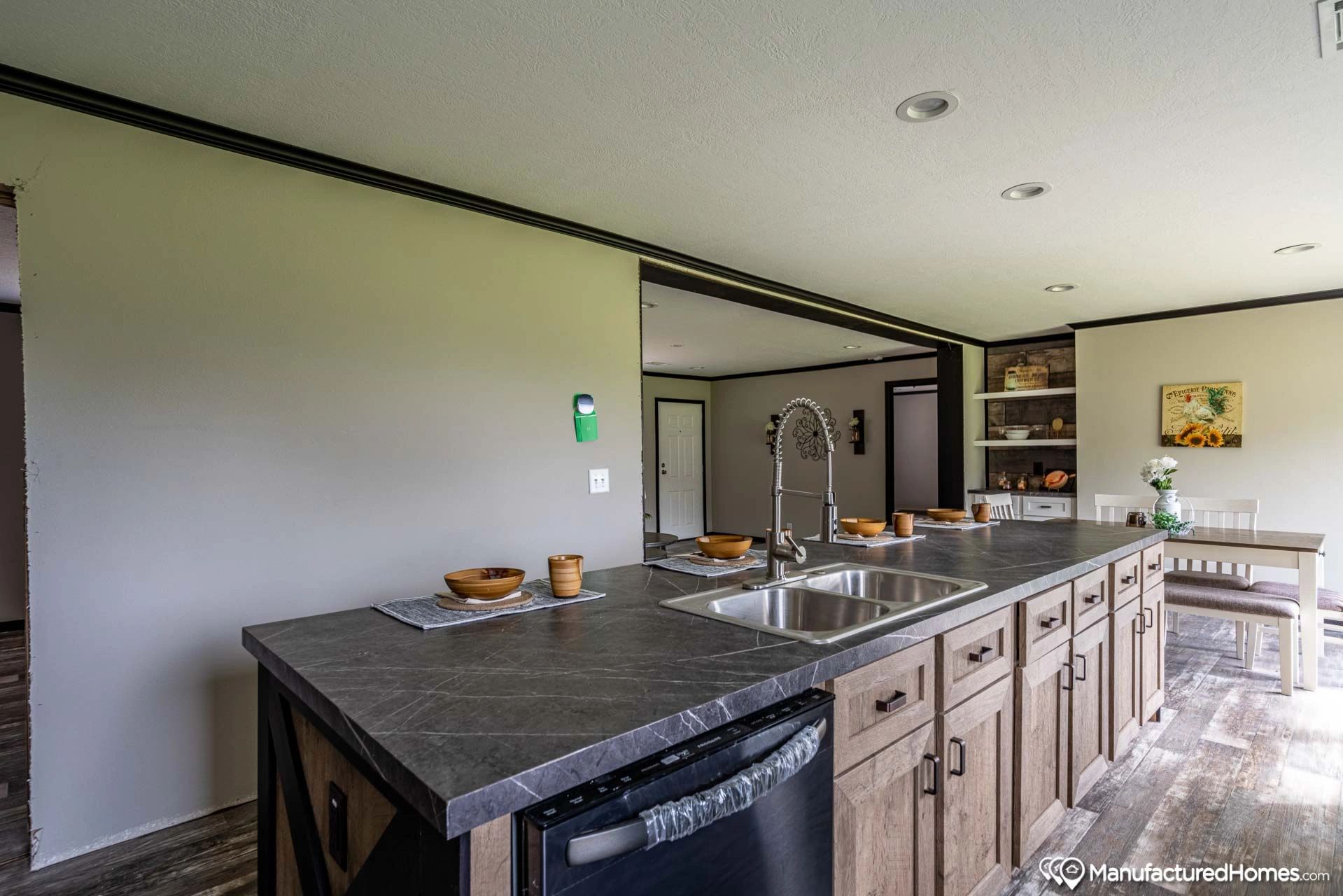 A kitchen with a large island , sink , and dishwasher.