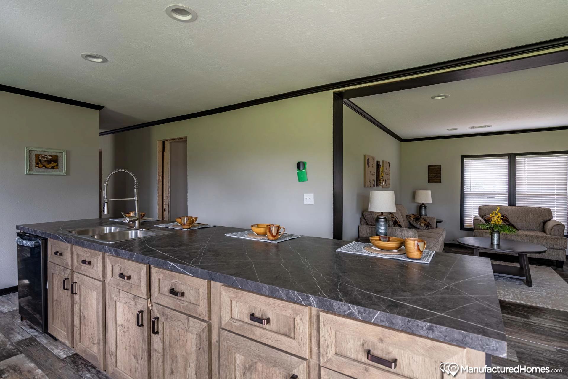 A kitchen in a mobile home with a large island and a sink.