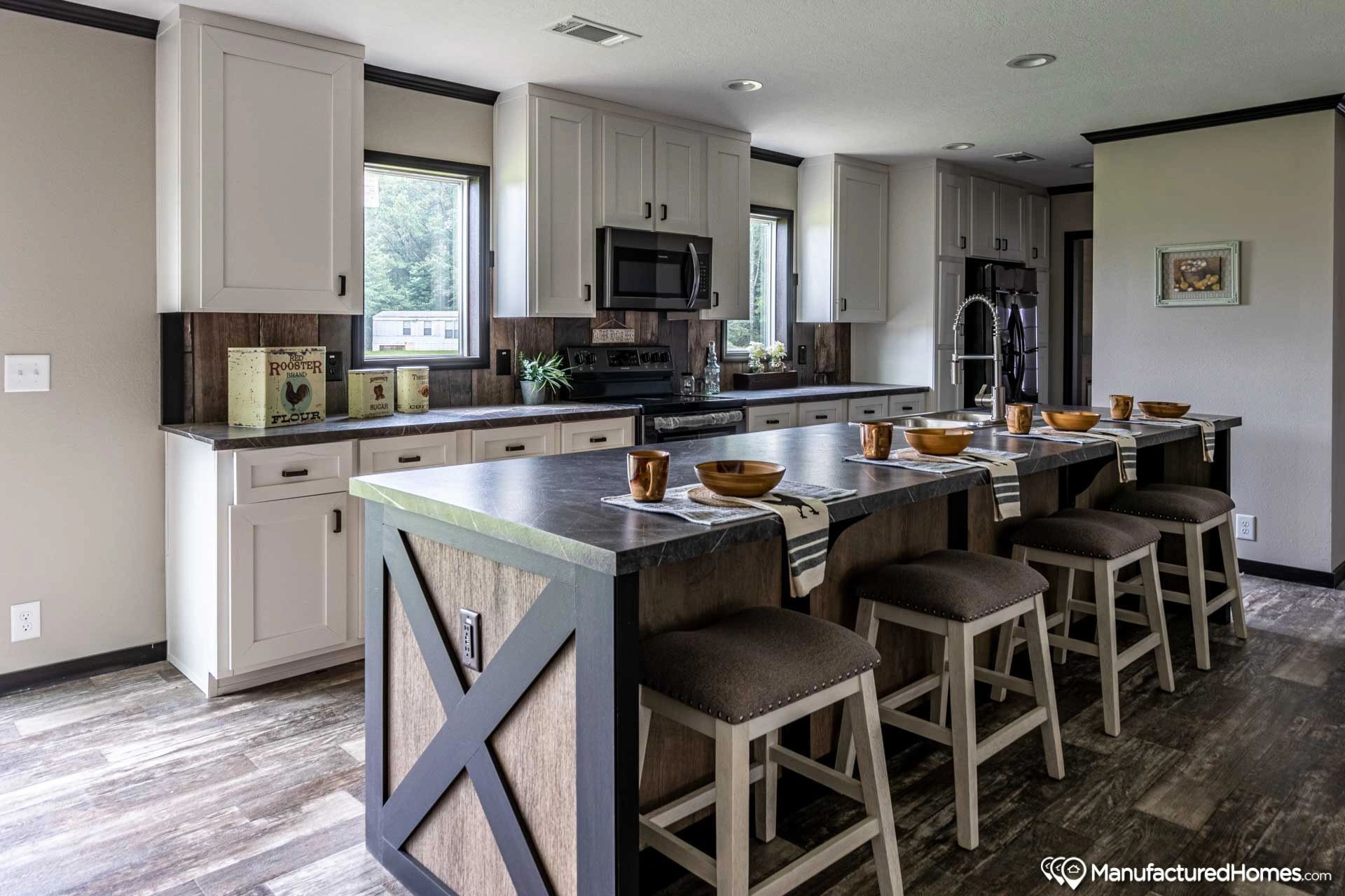 A kitchen with a large island and stools.