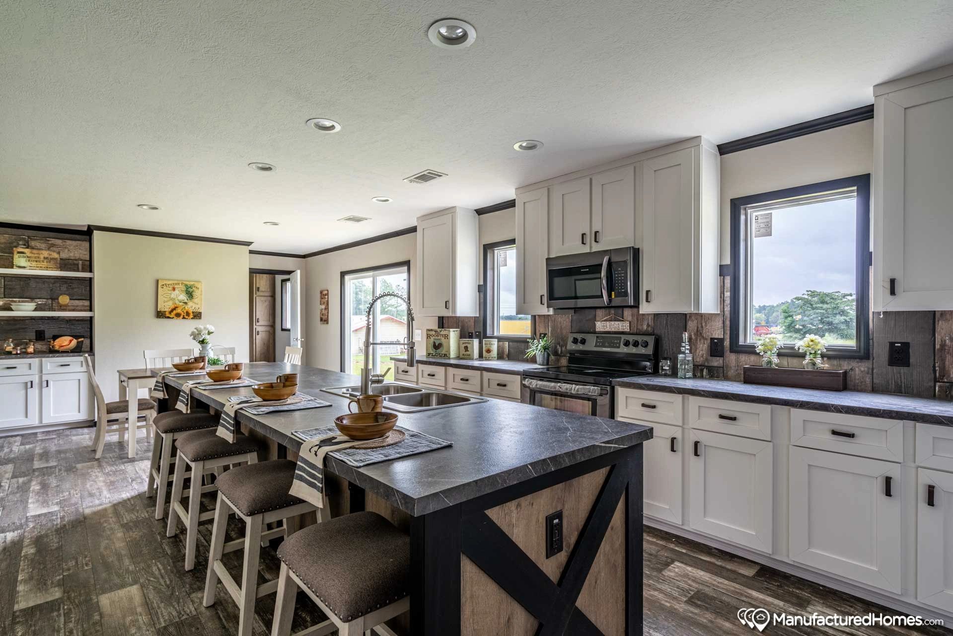 A kitchen with white cabinets and a large island in the middle.