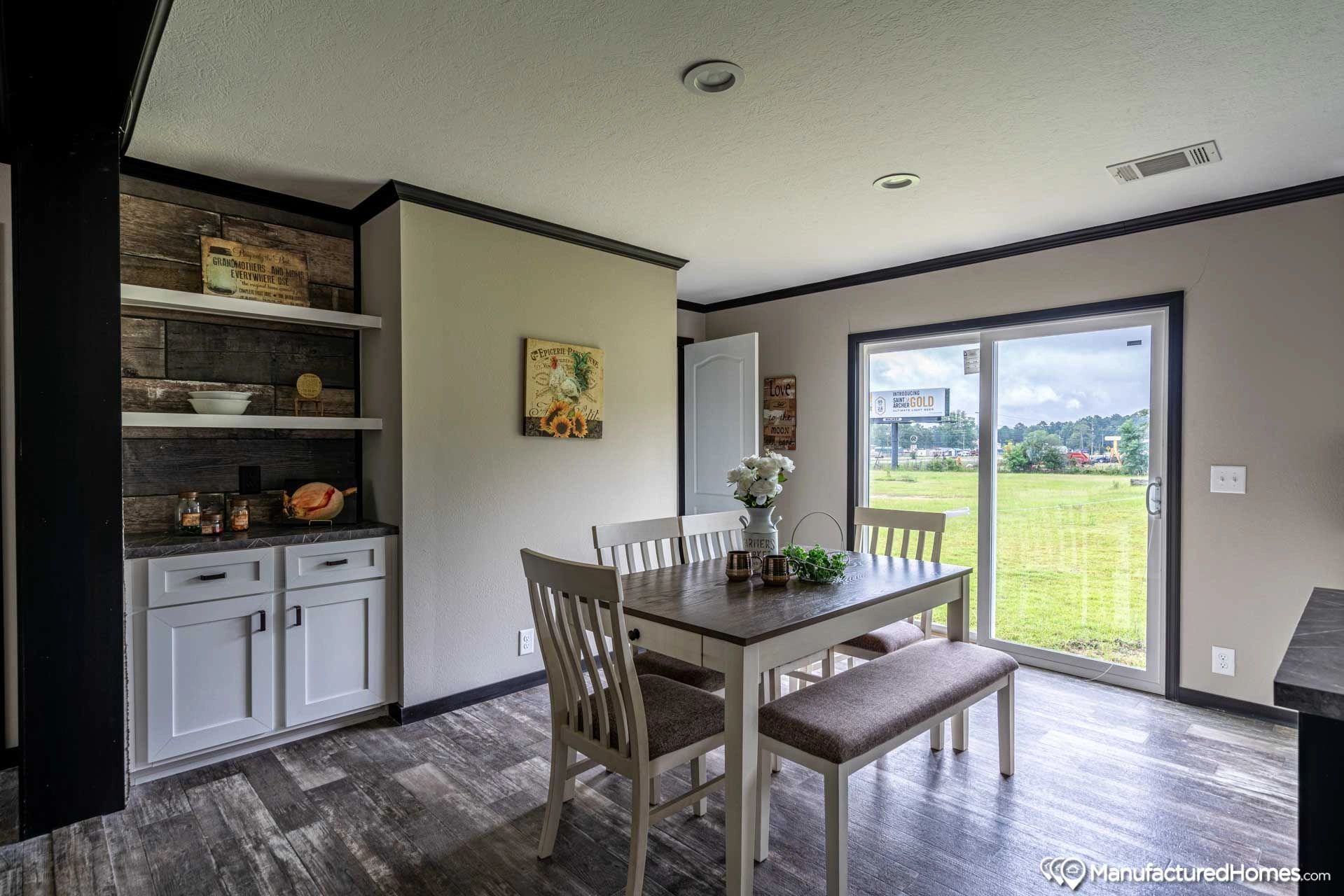 A dining room with a table and chairs and a sliding glass door.