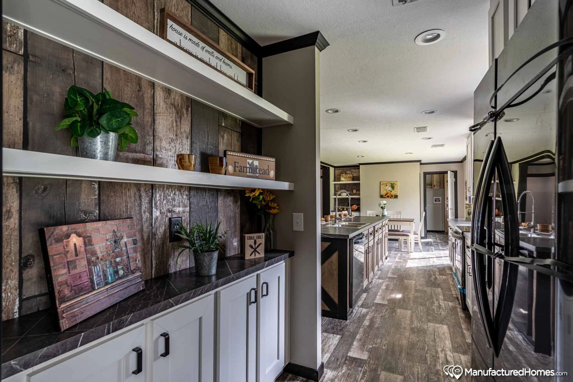 A kitchen with stainless steel appliances and wooden shelves.