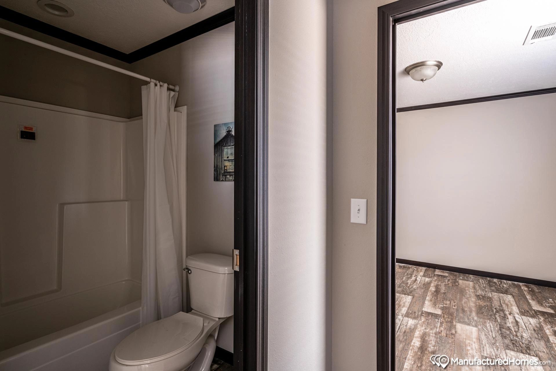 A bathroom with a toilet , tub and shower.