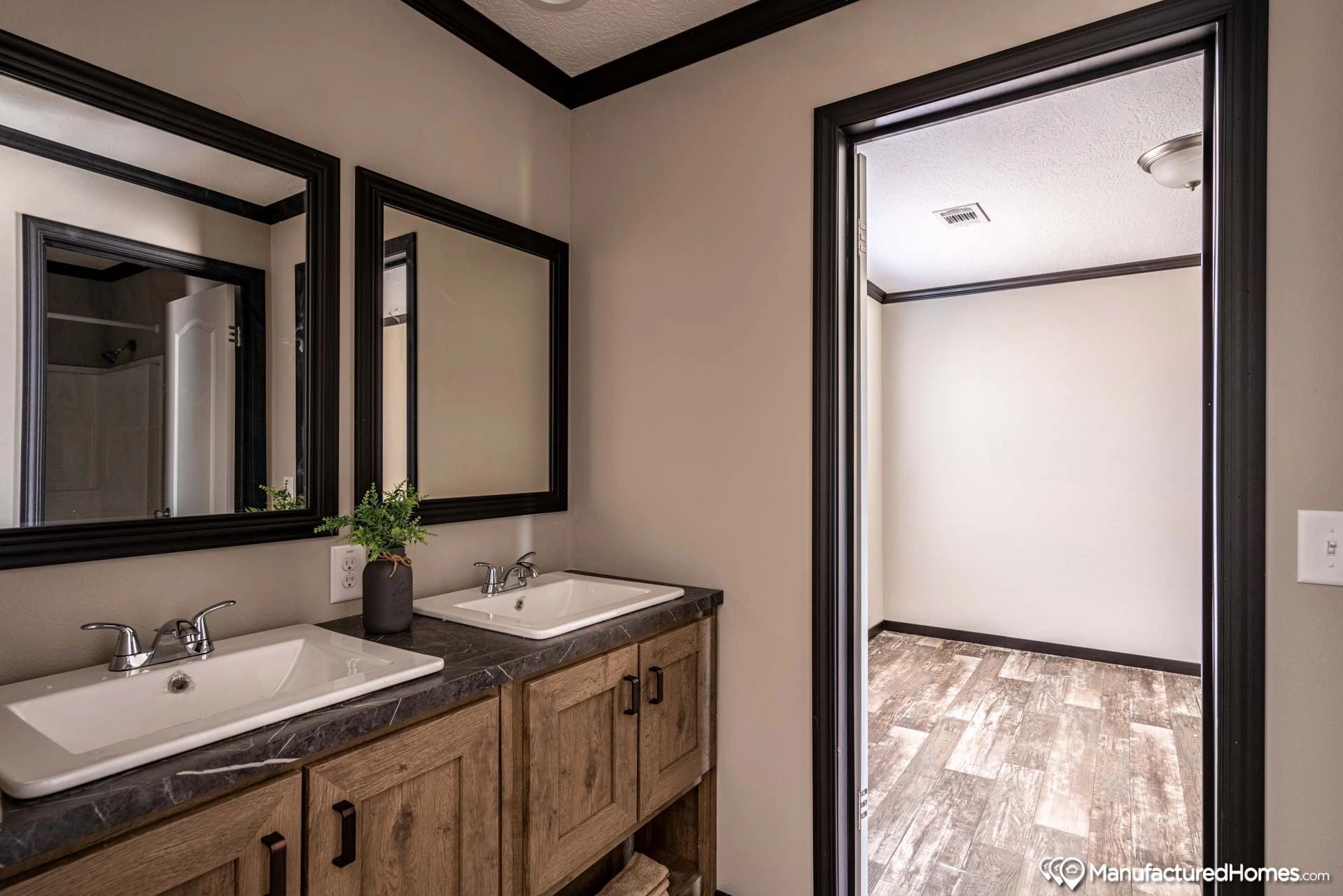 A bathroom with two sinks and two mirrors.