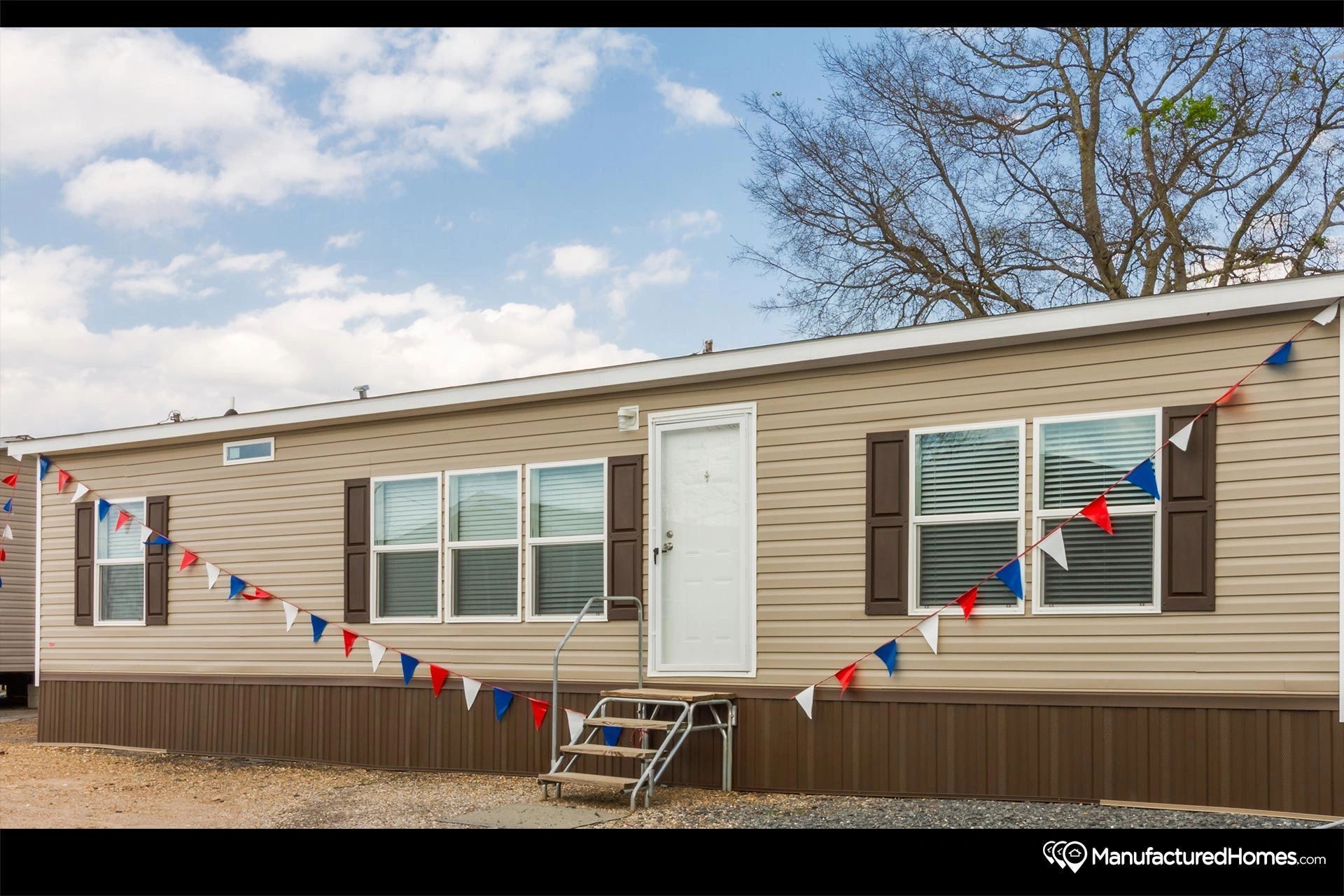 A mobile home with a lot of windows and flags on the side of it.