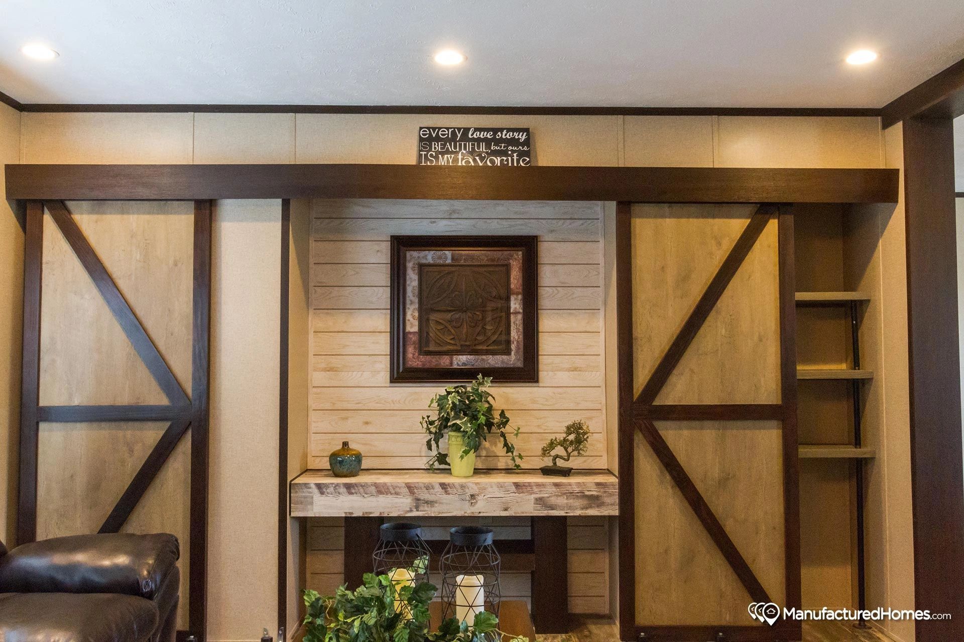 A living room with a sliding barn door and a couch.