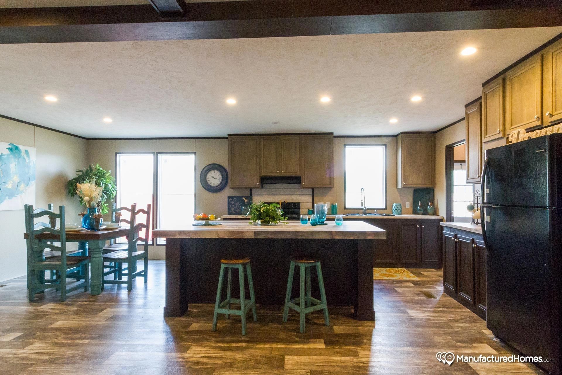 A kitchen with a large island and a dining room in the background.