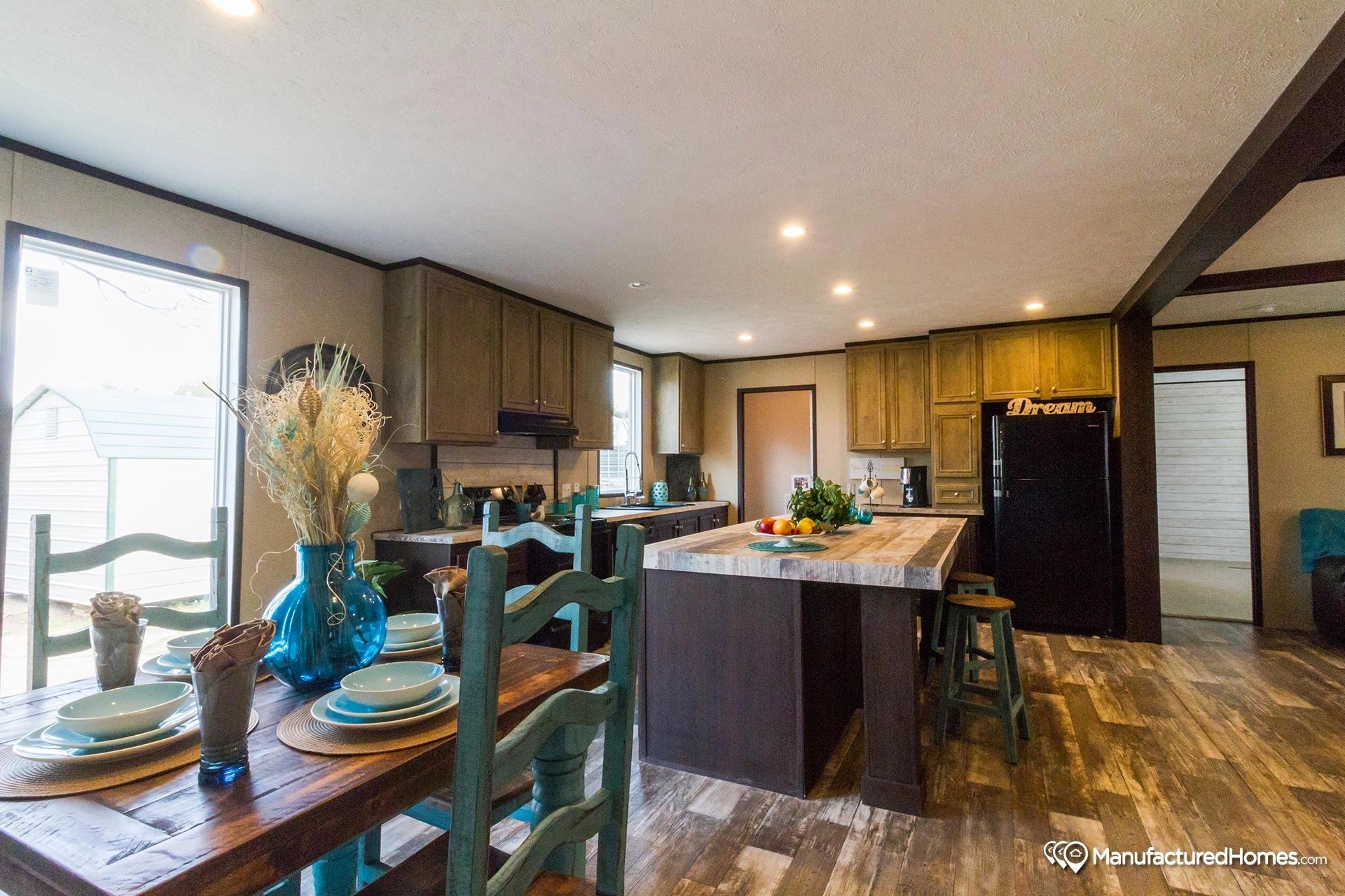 A kitchen and dining room in a mobile home with a table and chairs.