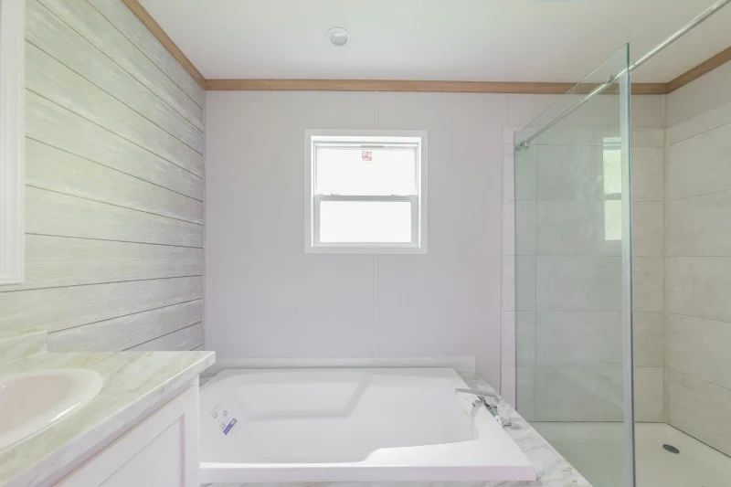 A bathroom with a tub , sink , and shower.