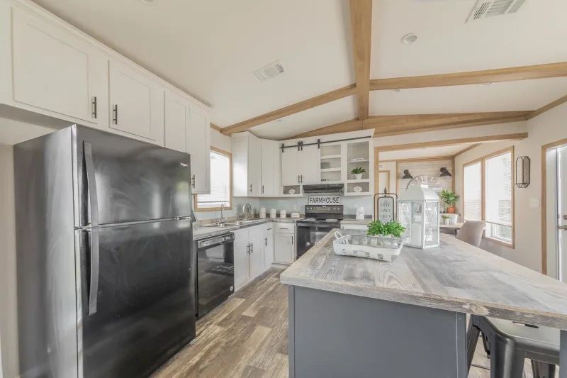 A kitchen in a mobile home with stainless steel appliances and a large island.