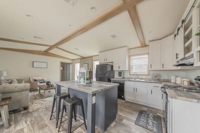 A kitchen in a mobile home with a large island and stools.