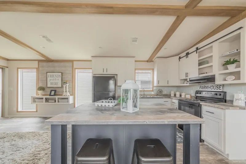 A kitchen with a large island and two stools.