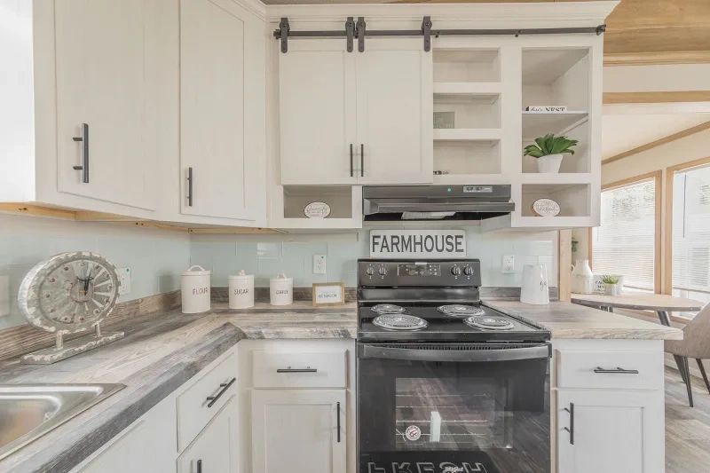 A kitchen with white cabinets , stainless steel appliances , a stove and a sink.