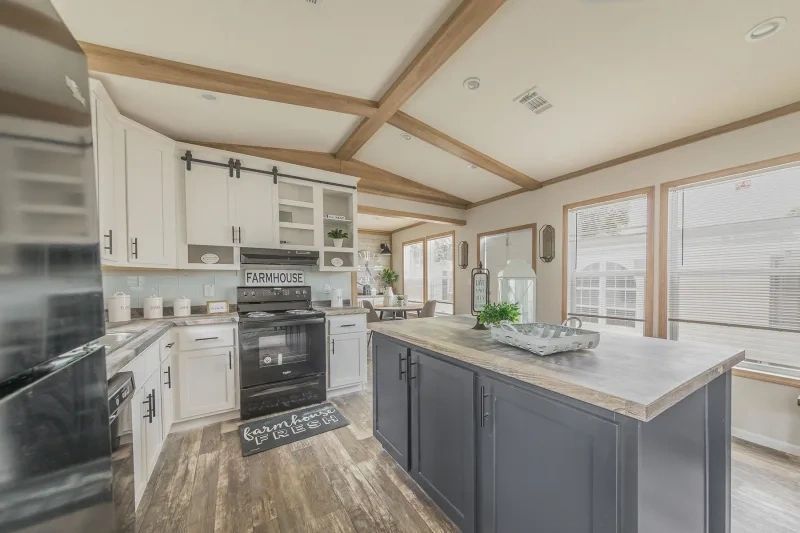 A kitchen in a mobile home with a large island in the middle.