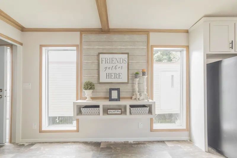 A living room with a sign on the wall that says `` friends gather here ''.