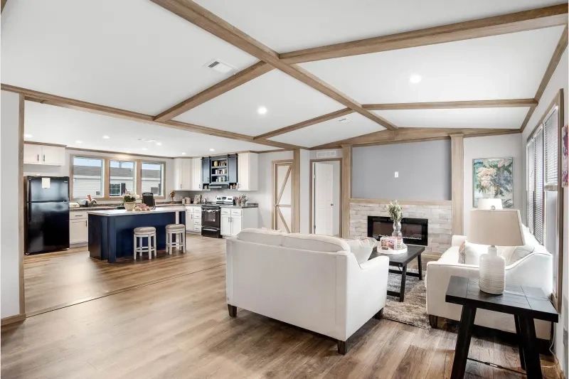 A living room filled with furniture and a kitchen in a mobile home.