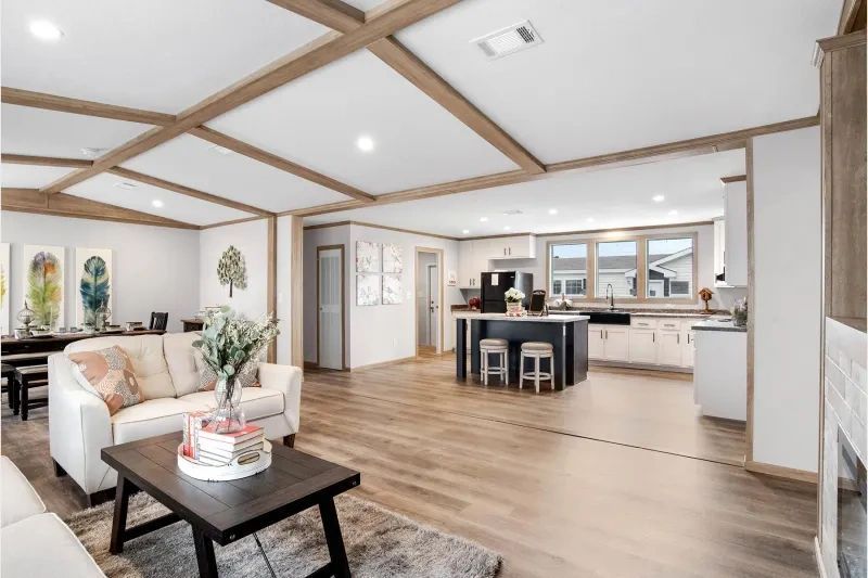 A living room with a couch , coffee table , and kitchen.