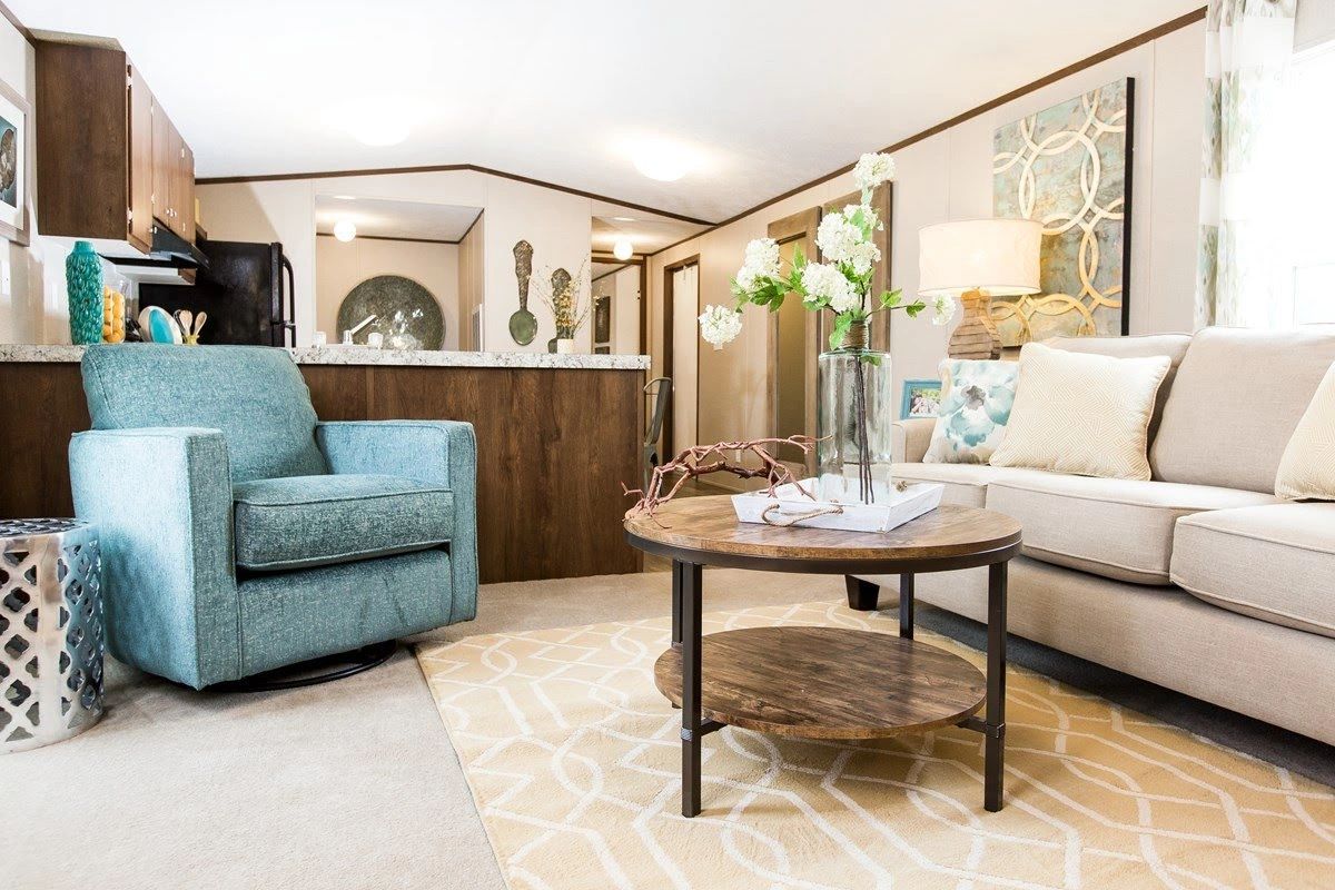 A living room with a couch , chair , coffee table and rug.