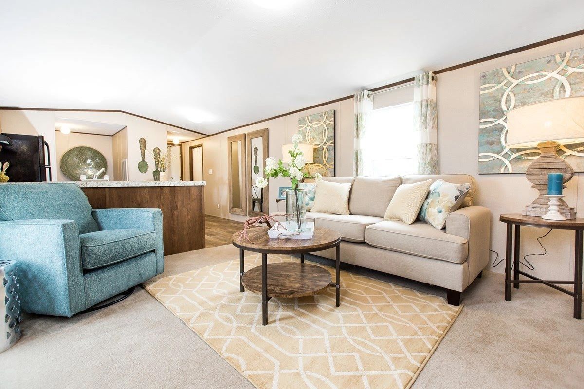 A living room with a couch , chair , coffee table and rug.