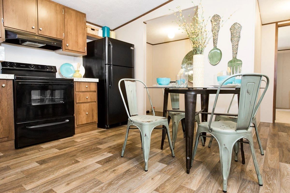 A kitchen with a table and chairs and a refrigerator.