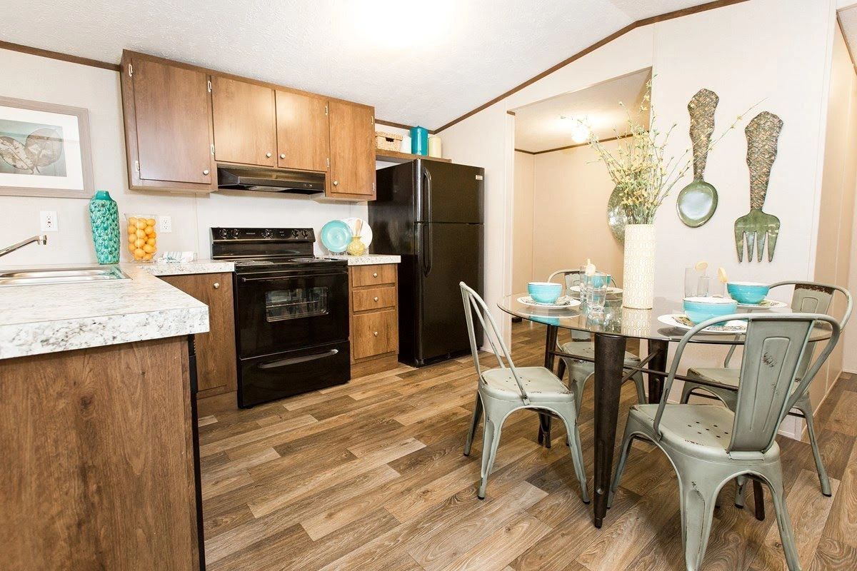 A kitchen with a table and chairs and a refrigerator.