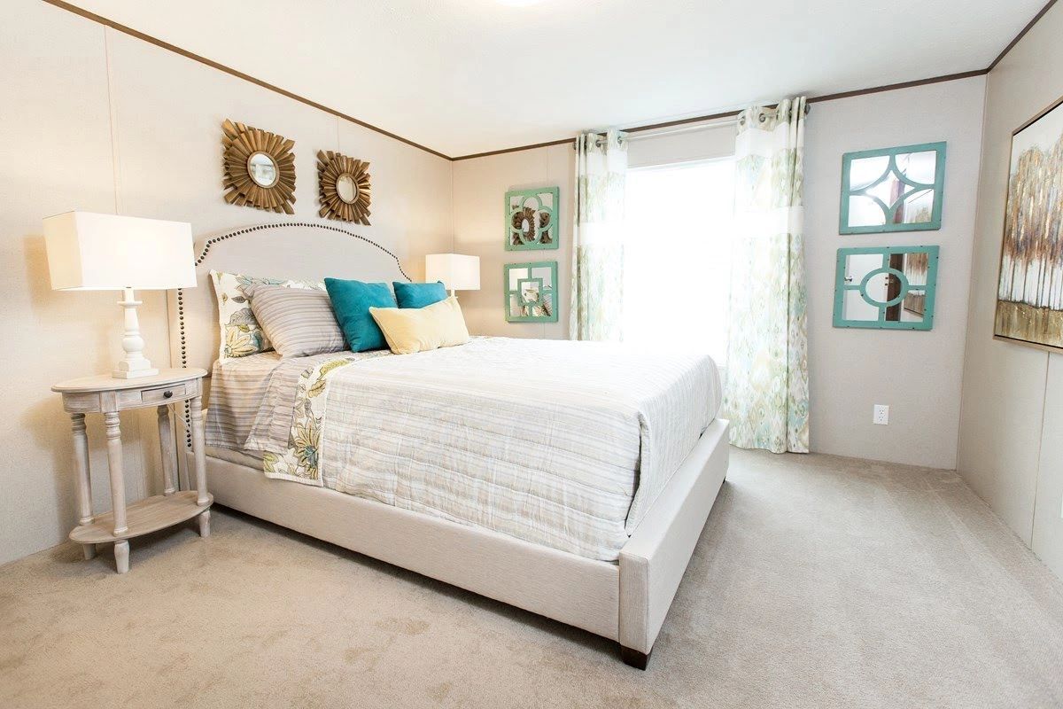 A bedroom with a large bed , two lamps , and a window.