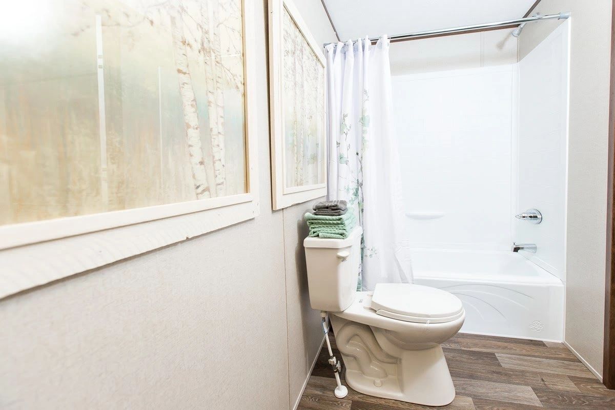 A bathroom with a toilet , tub and shower.