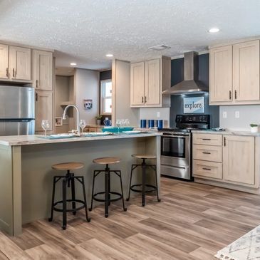 A kitchen with a large island and stools and a sign that says explore