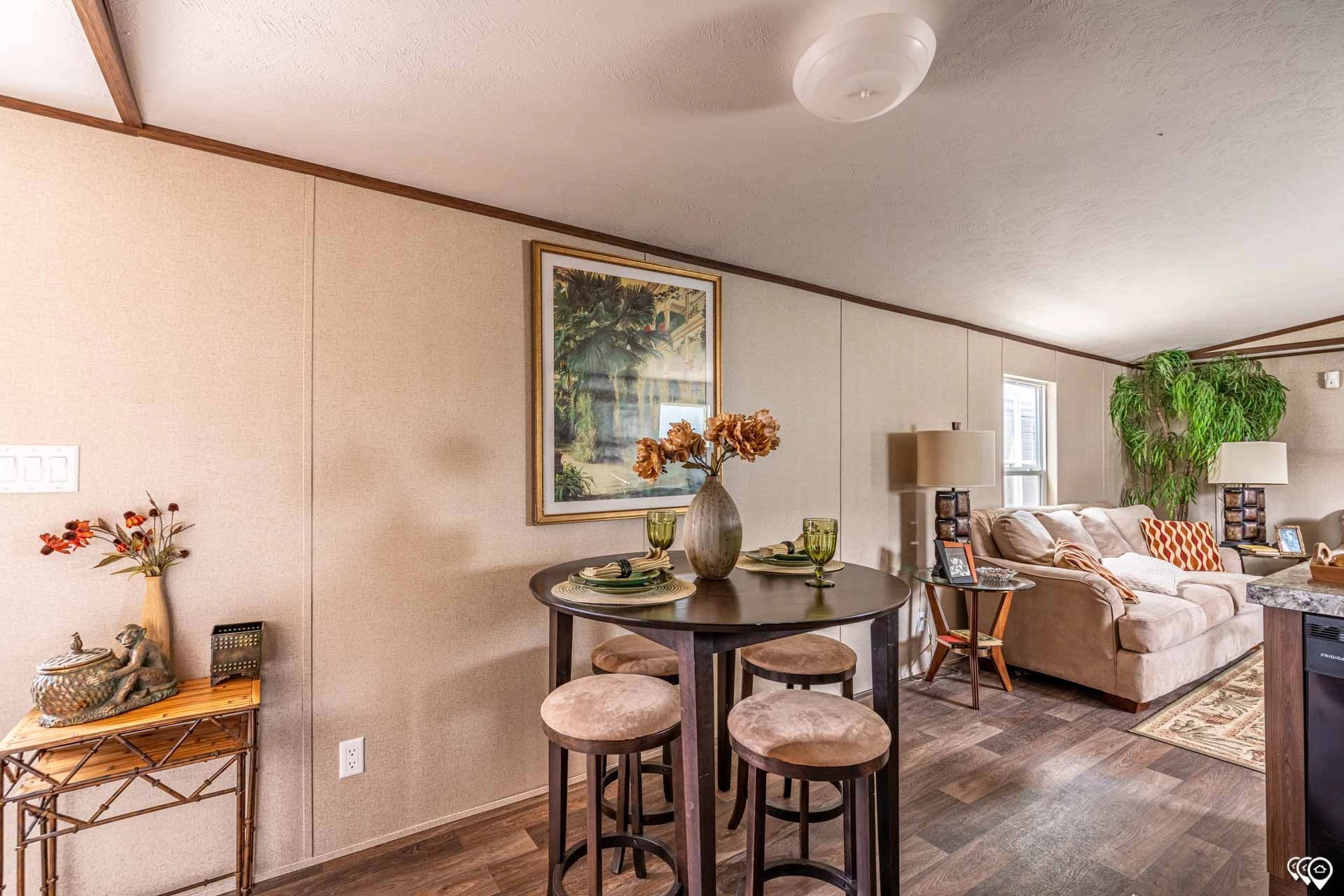 A living room with a table and stools and a couch.