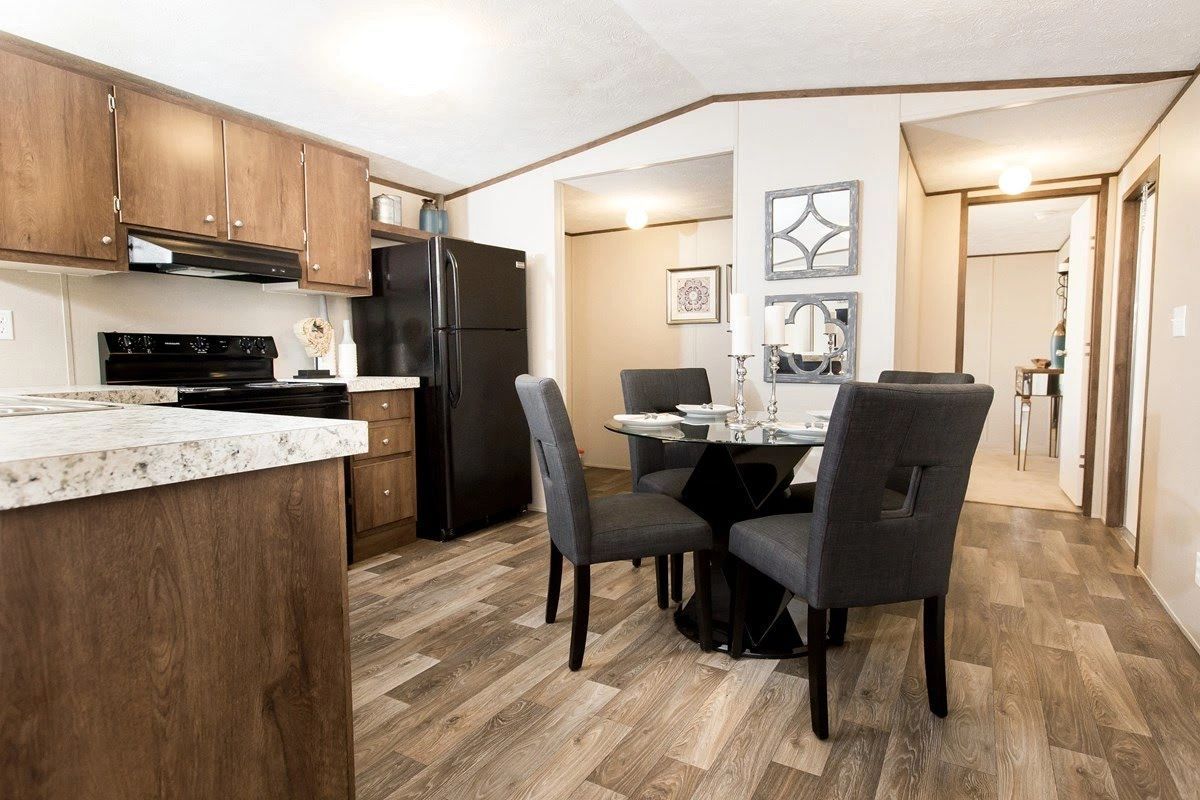 A kitchen and dining room in a mobile home with a table and chairs.