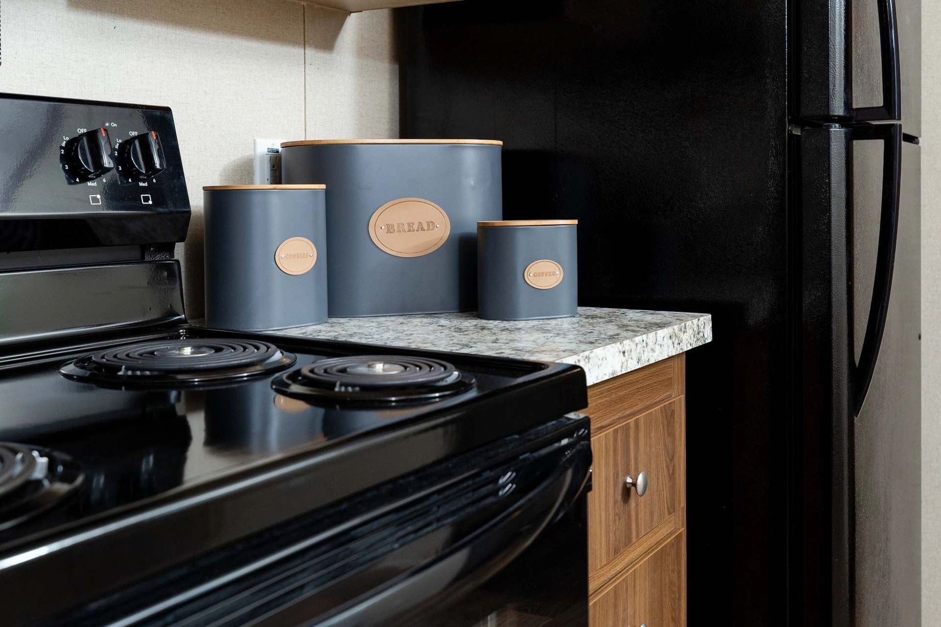 A kitchen with a black stove top oven and a black refrigerator