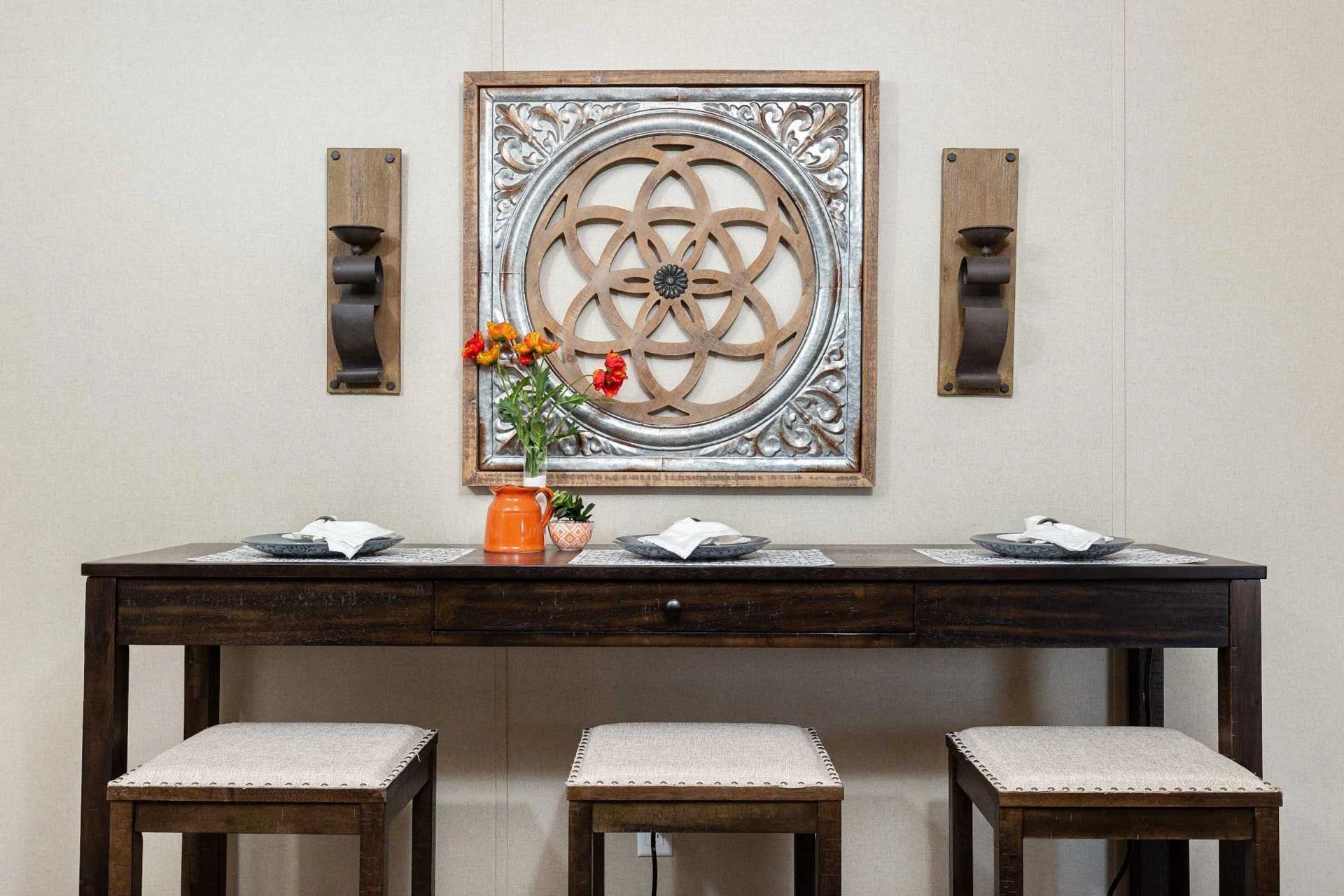 A dining room table with stools and a picture on the wall above it.