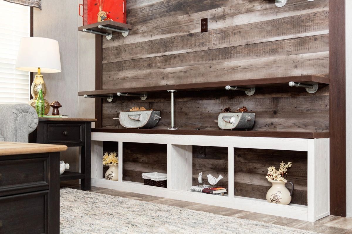 A living room with a wooden wall and shelves.
