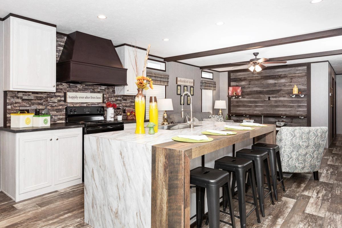 A kitchen with a large island and stools in a house.