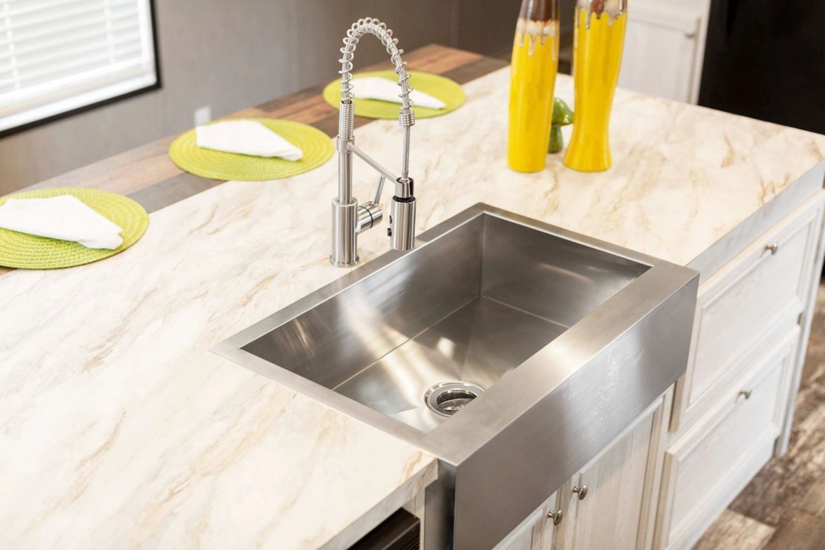 A kitchen with a stainless steel sink and a faucet.