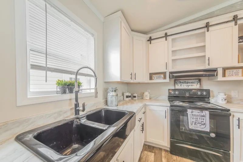 A kitchen with two sinks , a stove , and a window.