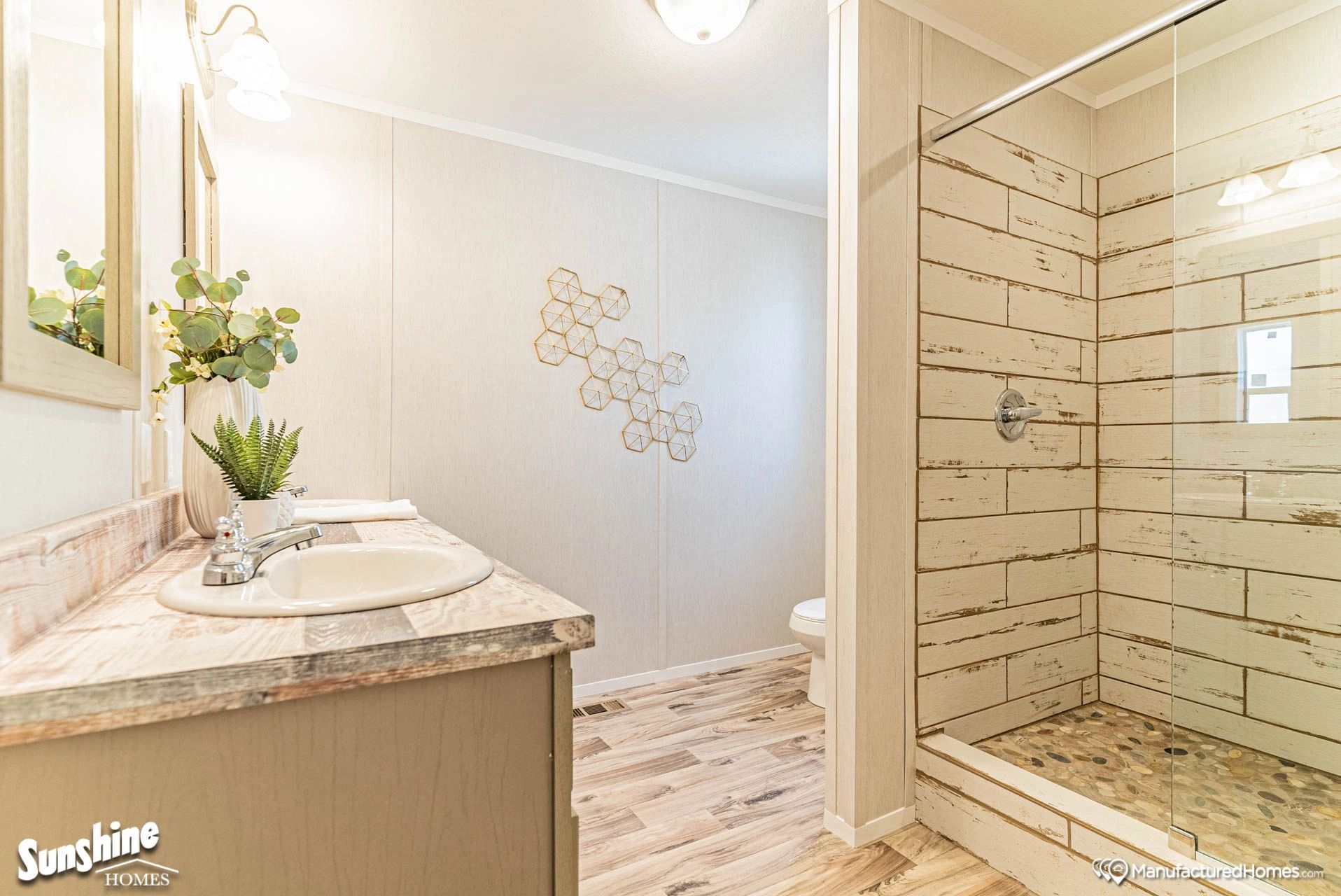 A bathroom with a sink and a walk in shower.