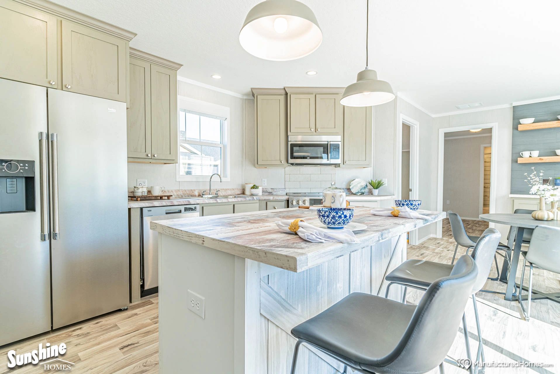A kitchen with stainless steel appliances and a large island.