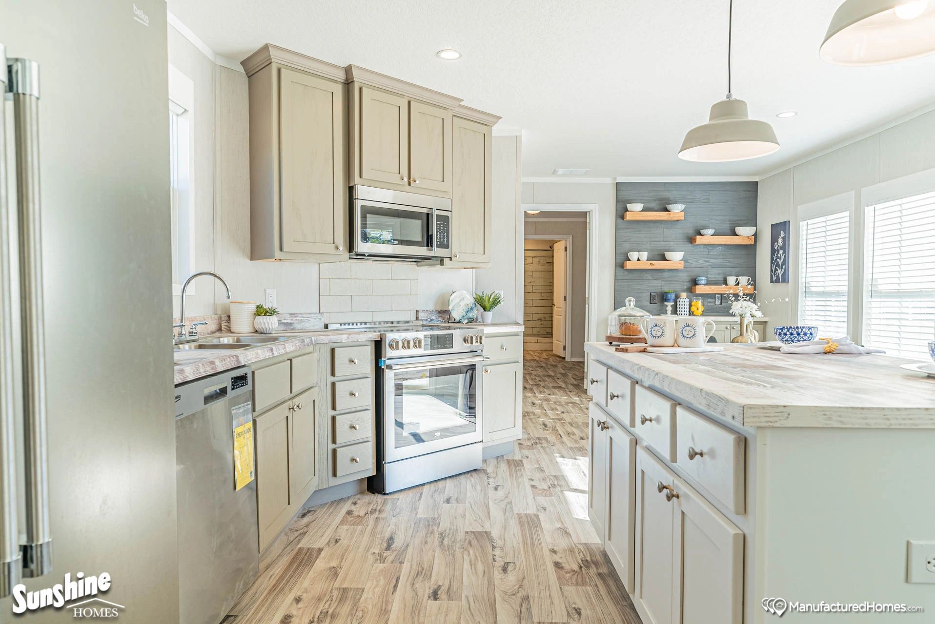 A kitchen in a mobile home with stainless steel appliances and a large island.