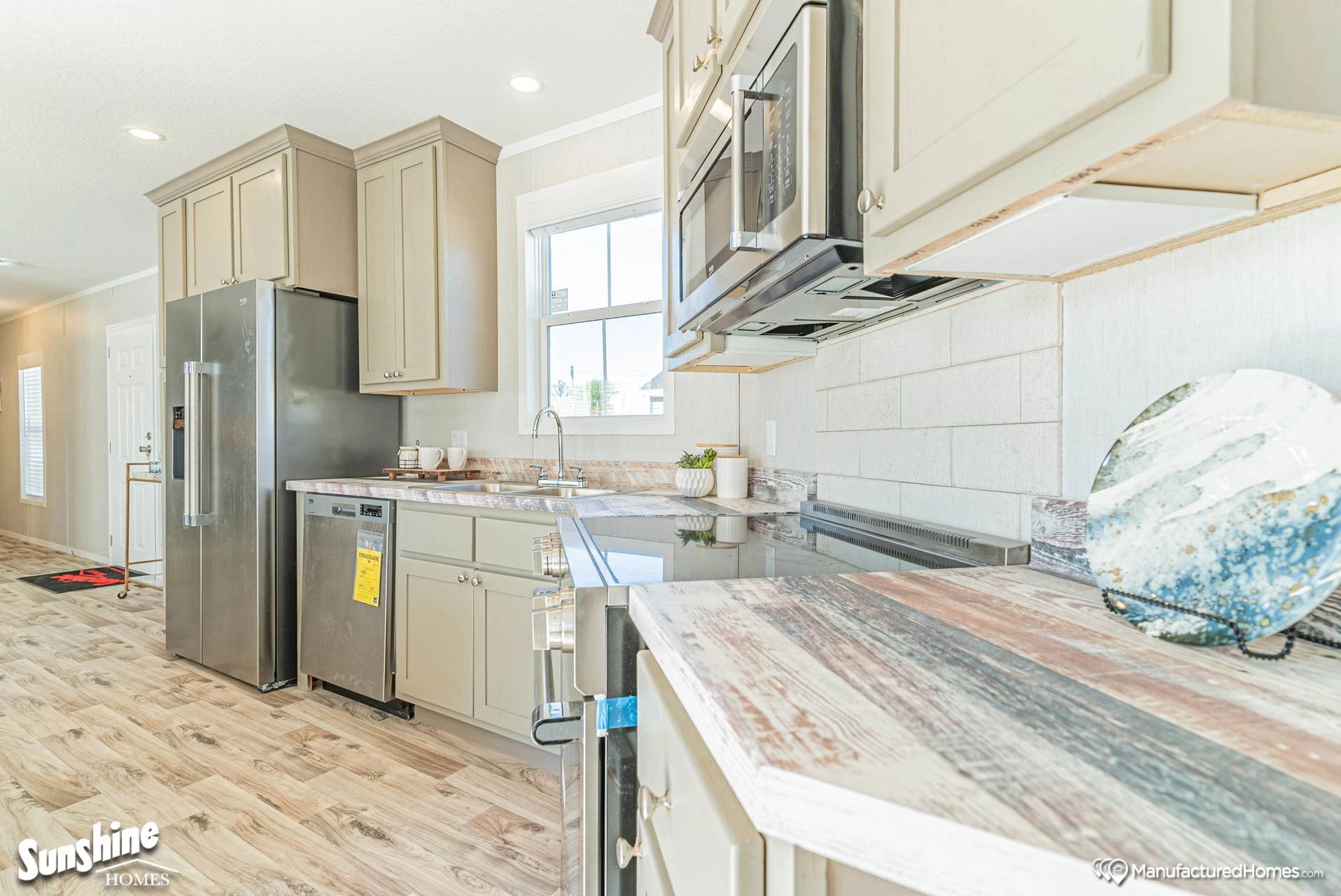 A kitchen in a mobile home with stainless steel appliances and white cabinets.