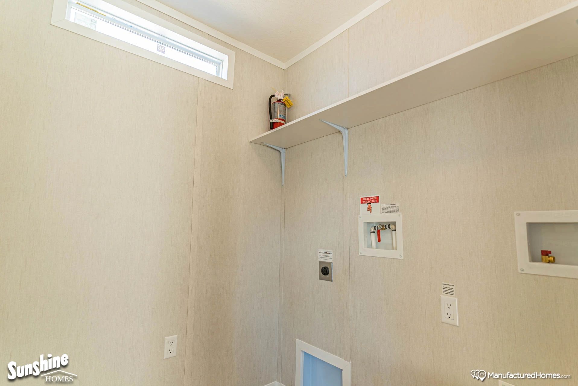 A laundry room in a mobile home with a window and a shelf.