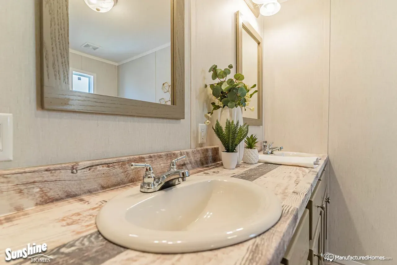 A bathroom with a sink and two mirrors.