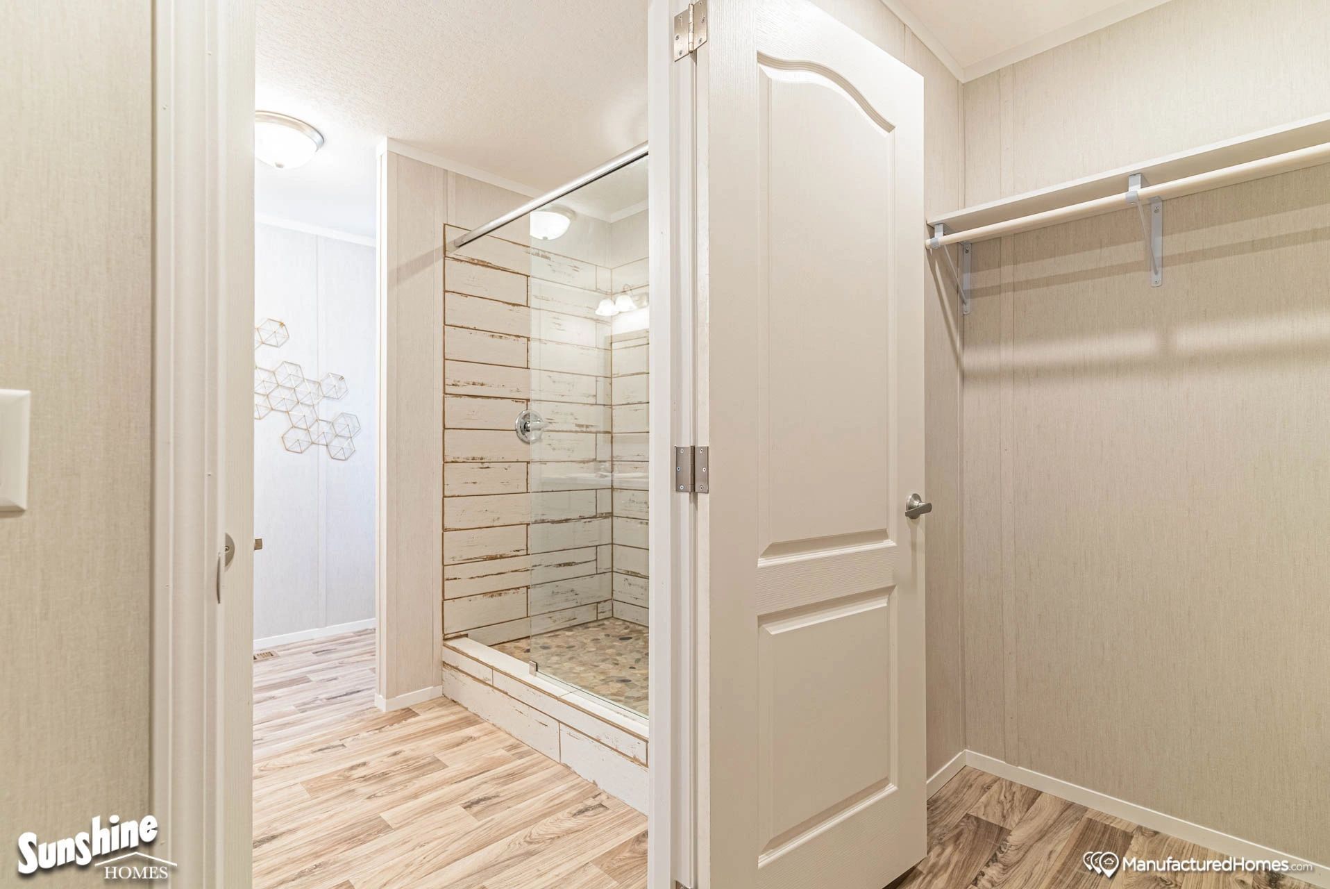 A walk in closet with a walk in shower in a mobile home.