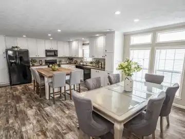 A kitchen and dining room in a mobile home with a table and chairs.