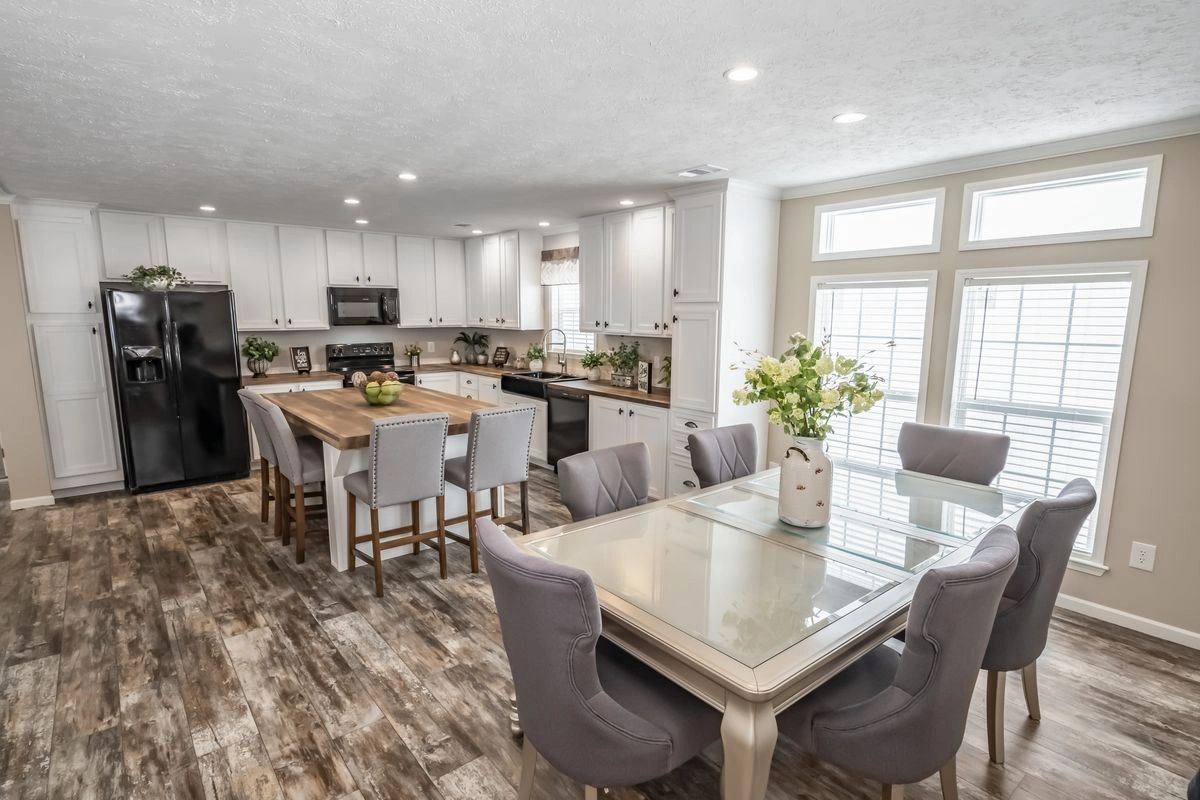 A kitchen and dining room in a mobile home with a table and chairs.