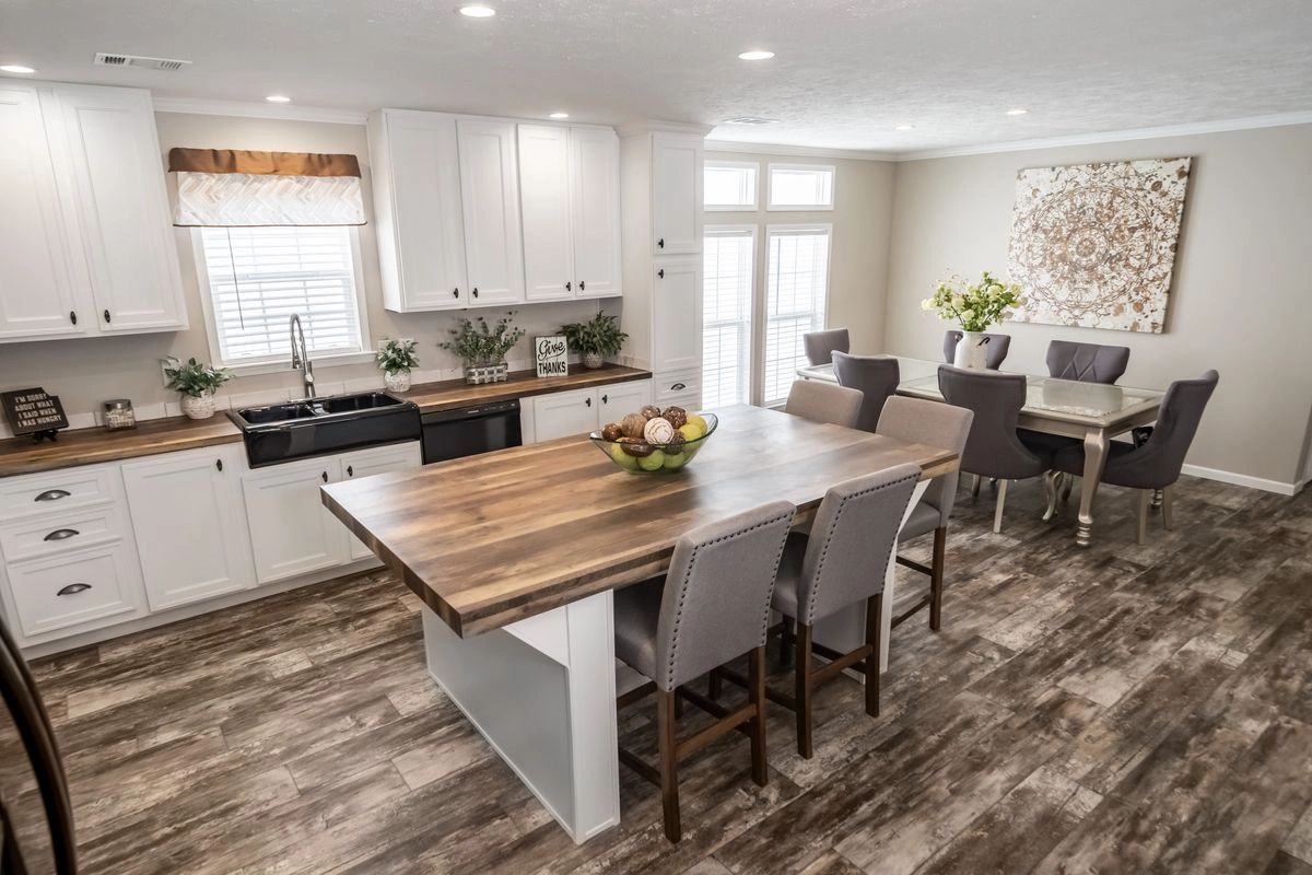 A kitchen and dining room in a house with a large wooden table and chairs.