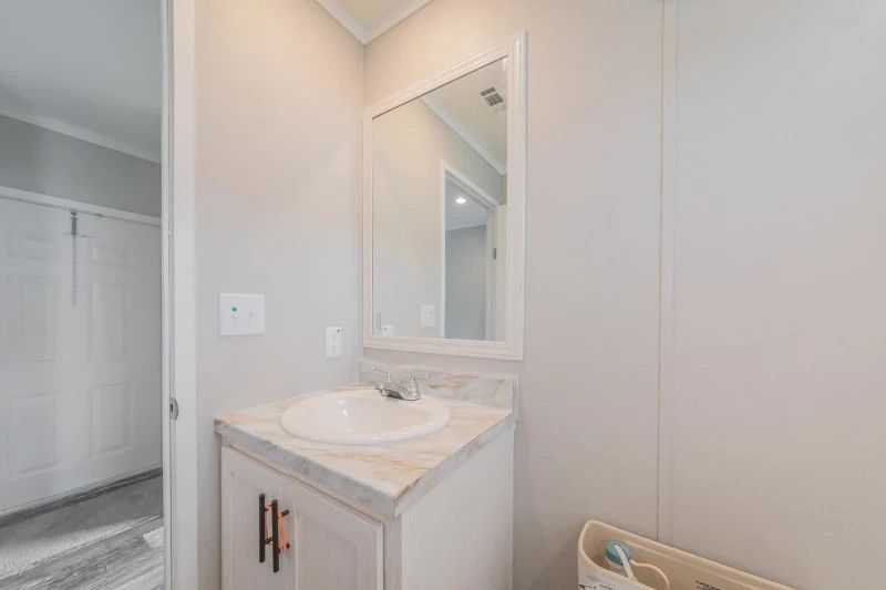A bathroom with a sink , mirror and cabinets.
